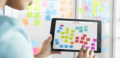 Ung dame som bruker App til å arbeide med Kanban-tavle og setter opp Kanban-tavle